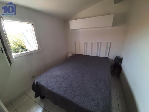 une petite chambre avec un lit et une fenêtre dans l'établissement Pavillon 6 pers, piscine, clim, parking, proche mer - FR-1-781-77, à Valras-Plage