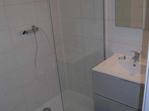 une douche avec une porte vitrée à côté d'un lavabo dans l'établissement Pavillon 6 pers, piscine, clim, parking, proche mer - FR-1-781-77, à Valras-Plage