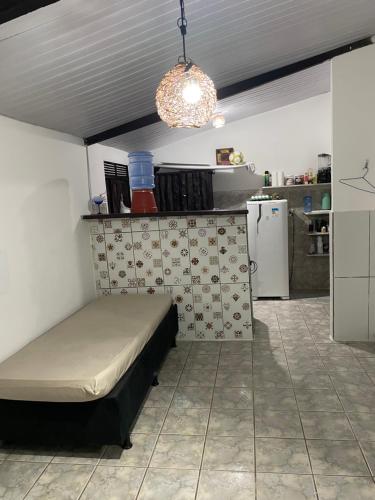 a small bedroom with a bed and a kitchen at Casa em Pipa ( Pipahouse) in Pipa