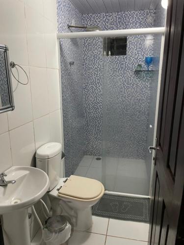 a bathroom with a shower and a toilet and a sink at Casa em Pipa ( Pipahouse) in Pipa