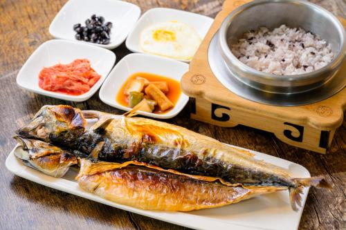 ein Teller mit Fisch und Reis auf dem Tisch in der Unterkunft Jeju M Resort in Seogwipo