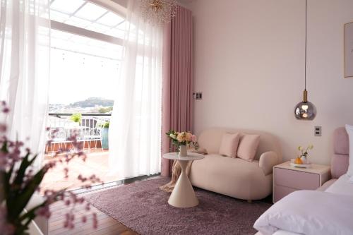 a living room with a couch and a large window at Dream Light Villa in Khu Chi Lăng