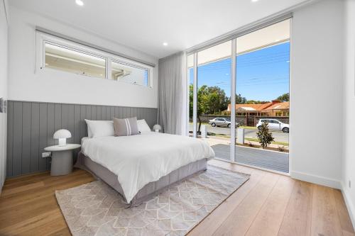 a bedroom with a bed and a large window at Drift at Palmstone - 2BR, Parking, Wifi in Glenelg