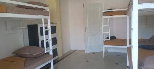 a room with three bunk beds in a room at The Cave house in Cochin