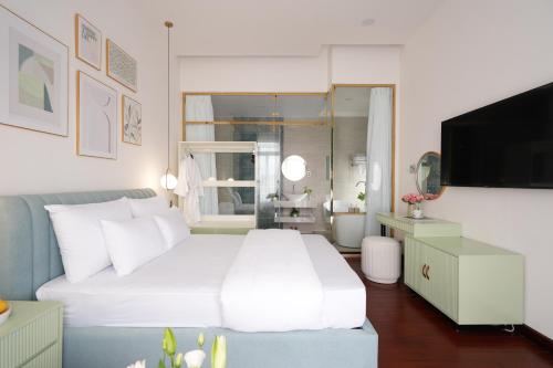 a bedroom with a large white bed and a television at Dream Light Villa in Khu Chi Lăng