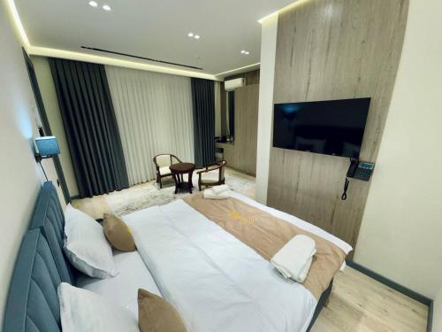 a hotel room with a bed and a flat screen tv at RIO Hotel in Samarkand