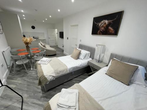 a room with two beds and a table with a dining room at Abbey Corner By Nivaas 4-Located in the heart of the city centre-5 minute walk to train station-20 minutes to London via train in Reading