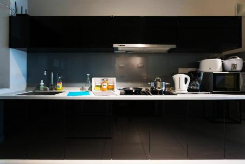 a kitchen with black cabinets and a white counter top at Maritime Suites Penang in Jelutong