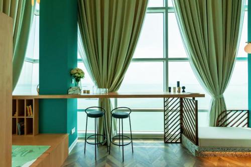 a table in front of a large window with stools at Maritime Suites Penang in Jelutong