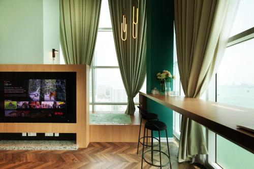 a living room with a flat screen tv and a bar at Maritime Suites Penang in Jelutong