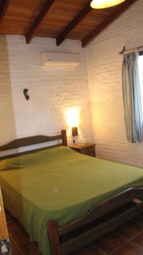 a bedroom with a green bed in a room at Casa 7 Cerros in Piriápolis
