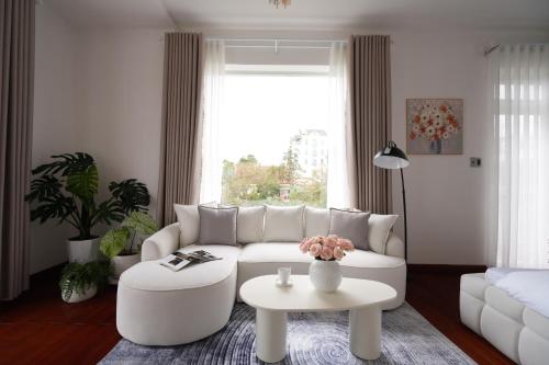 a living room with a white couch and a table at Dream Light Villa in Khu Chi Lăng