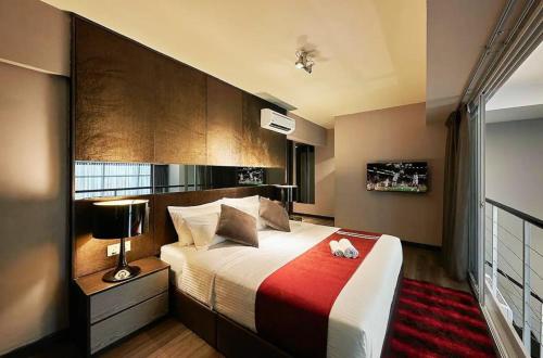 a bedroom with a large bed with a red blanket at Maritime Suites Penang in Jelutong