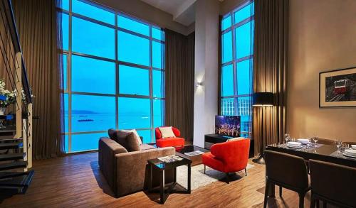 a living room with a large window with a view at Maritime Suites Penang in Jelutong