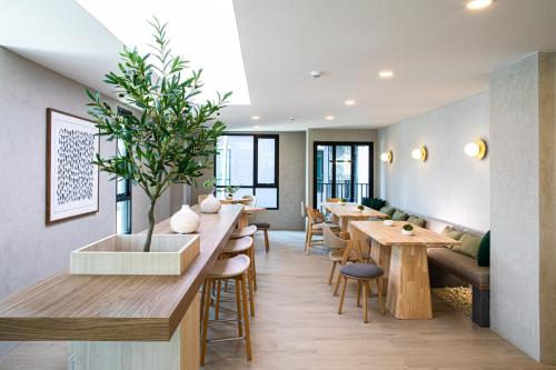 a restaurant with a long counter with tables and chairs at Wellness Stay & Hotel Sukhumvit 107 in Bangna