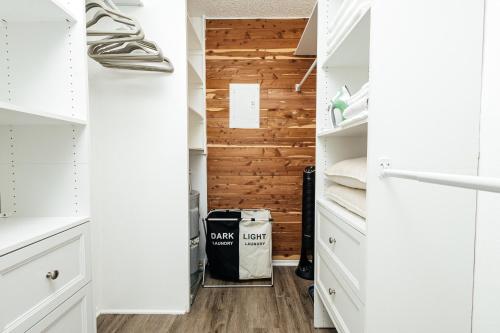 a walk in closet with white cabinets and a wooden wall at Breathtaking Oceanview Studio in Redondo Beach
