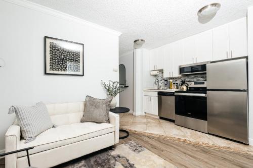 a living room with a white couch and a kitchen at Breathtaking Oceanview Studio in Redondo Beach