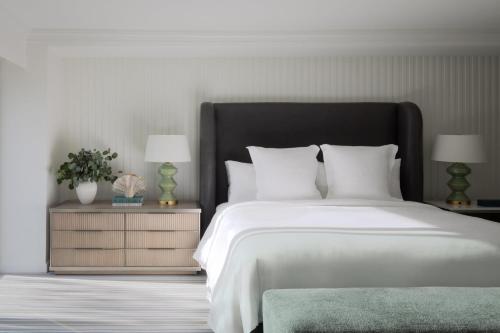 a bedroom with a large white bed with two lamps at Regent Santa Monica Beach in Los Angeles