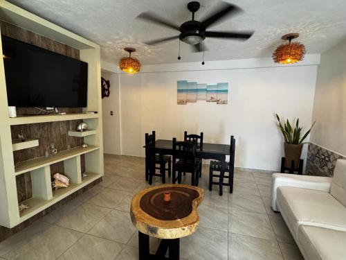 a living room with a table and a tv at Casa OAAL 1 in Isla Mujeres