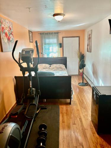 a bedroom with a bed and a room with a treadmill at STOPnREST EATnSLEEP FOR BUSY BODY ON THE MOVE in Queens