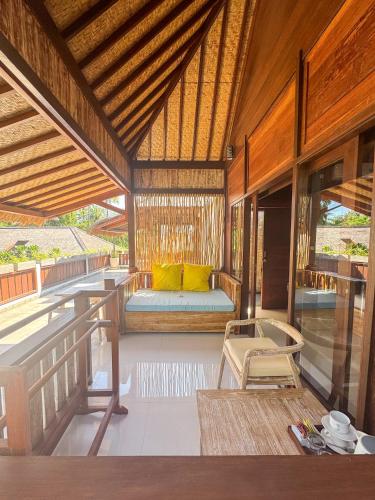 a pavilion with a bed and a bench on a porch at Villa Tahid in Gili Air