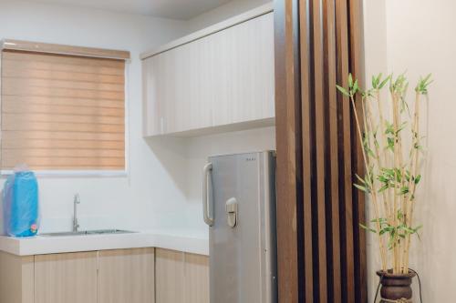 a kitchen with a refrigerator and a sink at Elyseah Condotel, Angeles Pampanga in Angeles