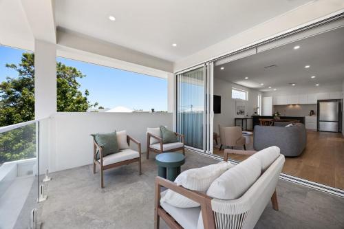 a living room with white furniture and a large window at Cove at Palmstone - 2BR, Parking, Wifi in Glenelg