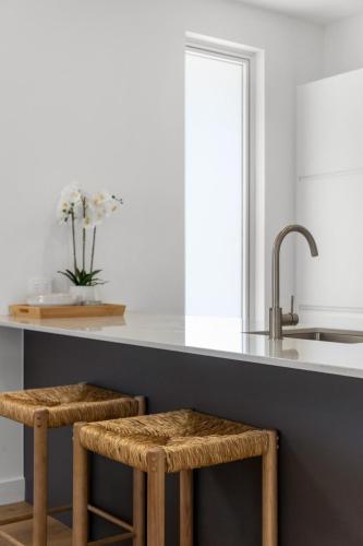 a kitchen with a counter with two stools at Cove at Palmstone - 2BR, Parking, Wifi in Glenelg
