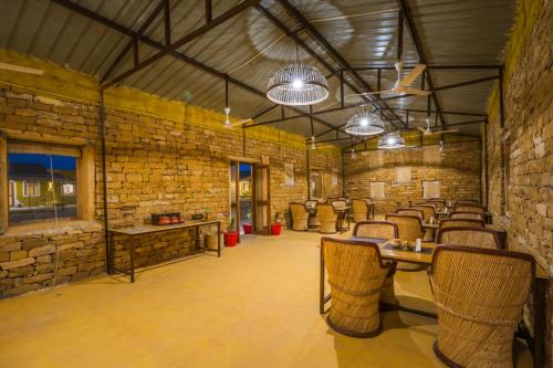 a room with tables and chairs in a brick wall at Vijay Bagh in Jaisalmer