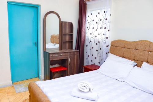 a bedroom with a large bed and a mirror at Adorable Homely Stay in Nakuru