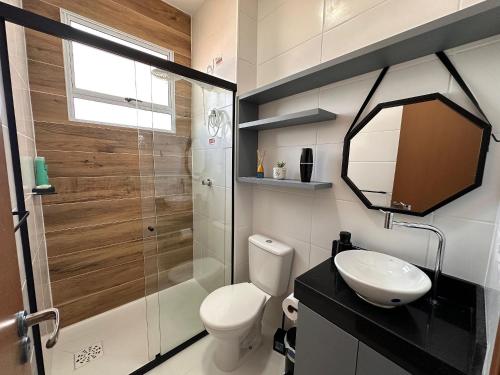 a bathroom with a shower and a toilet and a sink at Apartamento na praia, 2 quartos e área de lazer in Cabedelo