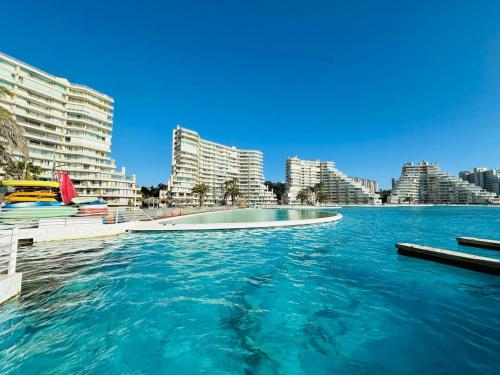 a large body of water with buildings in the background at San Alfonso del Mar la mejor vista de Algarrobo in Algarrobo