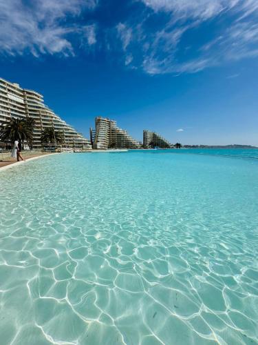 a view of the ocean with buildings in the background at San Alfonso del Mar la mejor vista de Algarrobo in Algarrobo