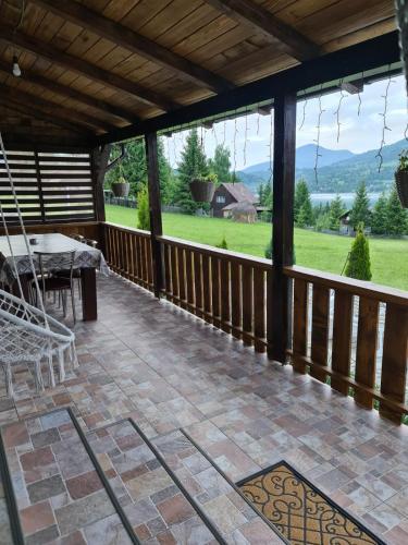 a screened in porch with a swing and a table at Cabana Busuioc in Colibiţa