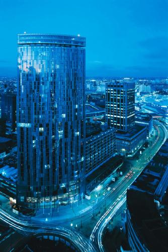 a large glass building in a city at night at Radisson Blu Hotel, Birmingham in Birmingham