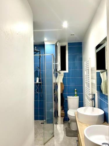 une salle de bain bleue avec des toilettes et un lavabo dans l'établissement Excellent 3BR 69m2 Puteaux, à Puteaux