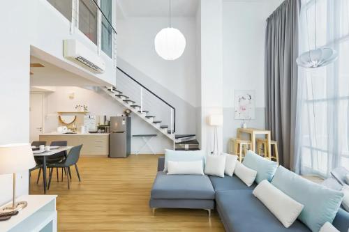 a living room with a blue couch and a kitchen at Maritime Suites Penang in Jelutong