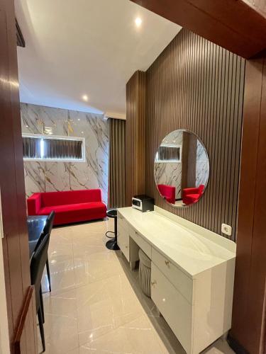 a living room with a red couch and a mirror at Gets Hotel in Malang