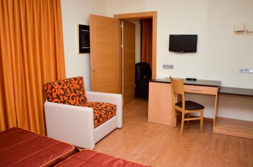 a hotel room with a chair and a desk at Hotel Malena in Caravaca de la Cruz