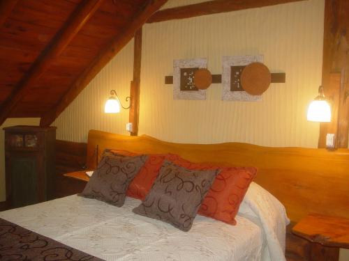 1 dormitorio con 1 cama con 2 almohadas en Patagonia Playa Suites en Mar de las Pampas