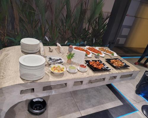 a table with plates of food and appetizers at Nyast Valley Resort by Autumleafs, Goa in Arpora