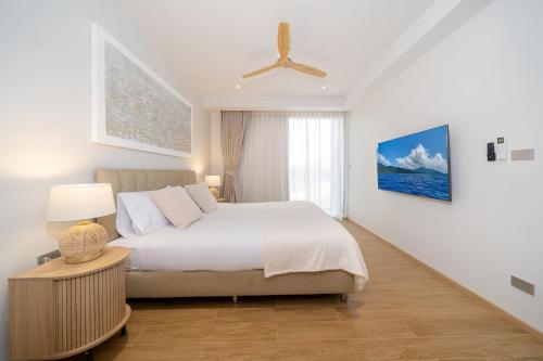 a bedroom with a bed and a ceiling fan at Laguna Beachside Residents in Phuket