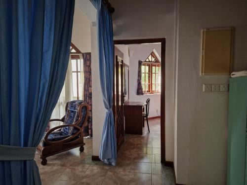 a living room with a blue curtain and a chair at Castle villa in Hikkaduwa
