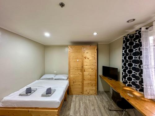 Un dormitorio con una cama y un televisor. en Misty Hills, en Baguio