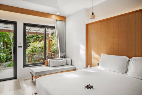 a bedroom with a large white bed and a window at Baan Chaweng Beach Resort & Spa - SHA Extra Plus in Chaweng