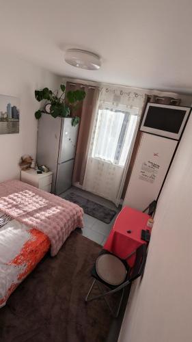 蒙特勒伊à 30 minutes de tour Eiffel的一间卧室，有一张床和一把红椅子