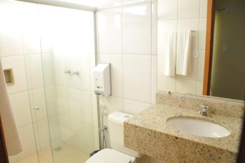 y baño con aseo, lavabo y ducha. en Sueds Premium, en Porto Seguro