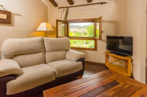 a living room with a couch and a tv at Font del Pas in Beceite