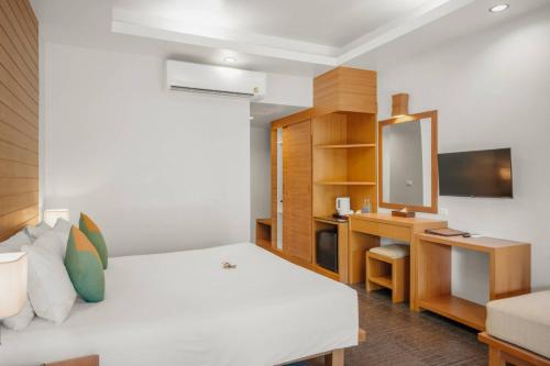 a bedroom with a white bed and a tv at Baan Chaweng Beach Resort & Spa - SHA Extra Plus in Chaweng