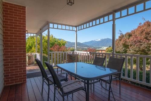 a patio with a table and chairs on a deck at Neve e Fiume Snow and River in Tawonga